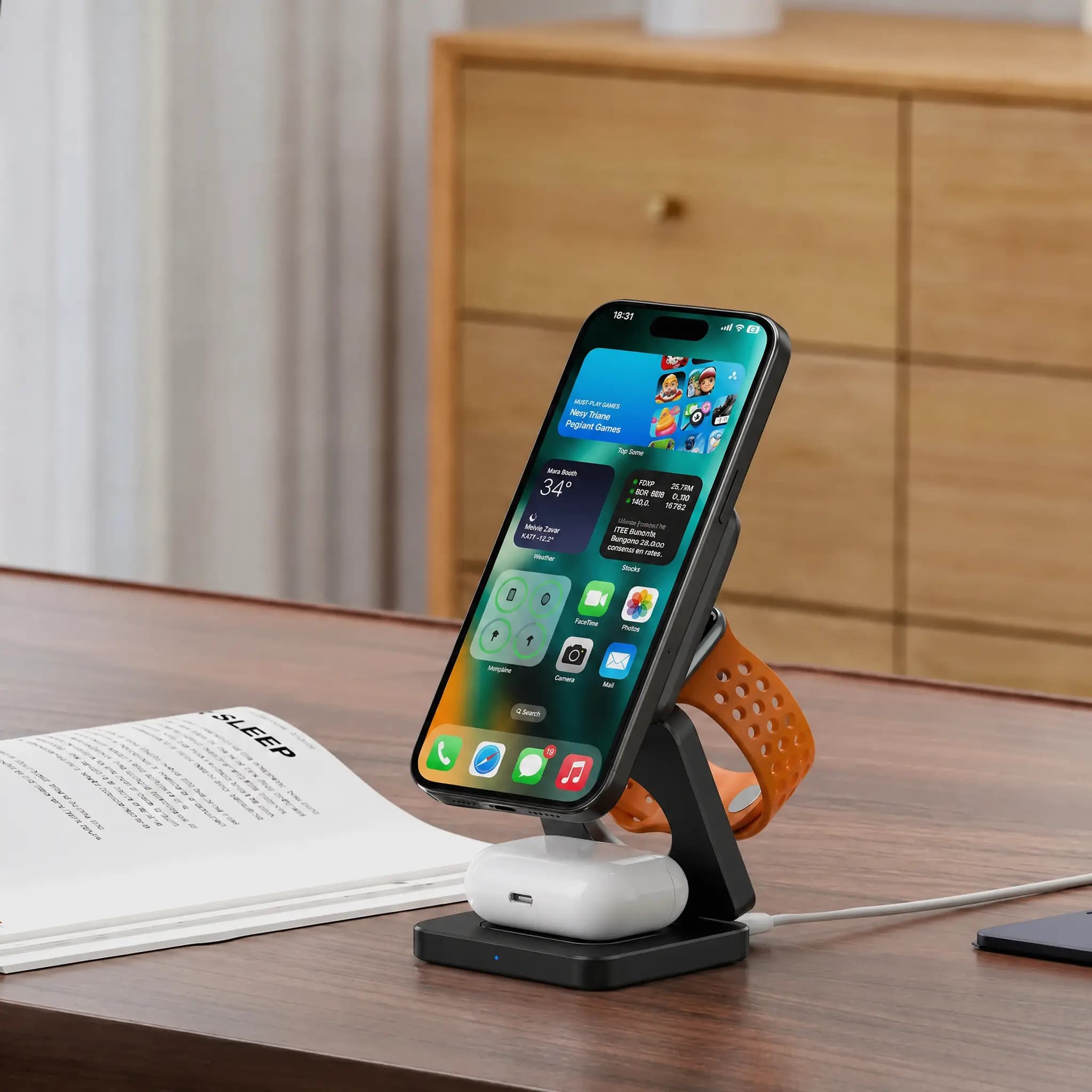 Cargador plegable 3 en 1 negro en un escritorio, con el celular en vertical, el reloj y los audífonos