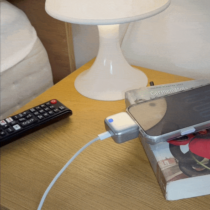 Adaptador de parada automática junto a un teléfono cargando de noche